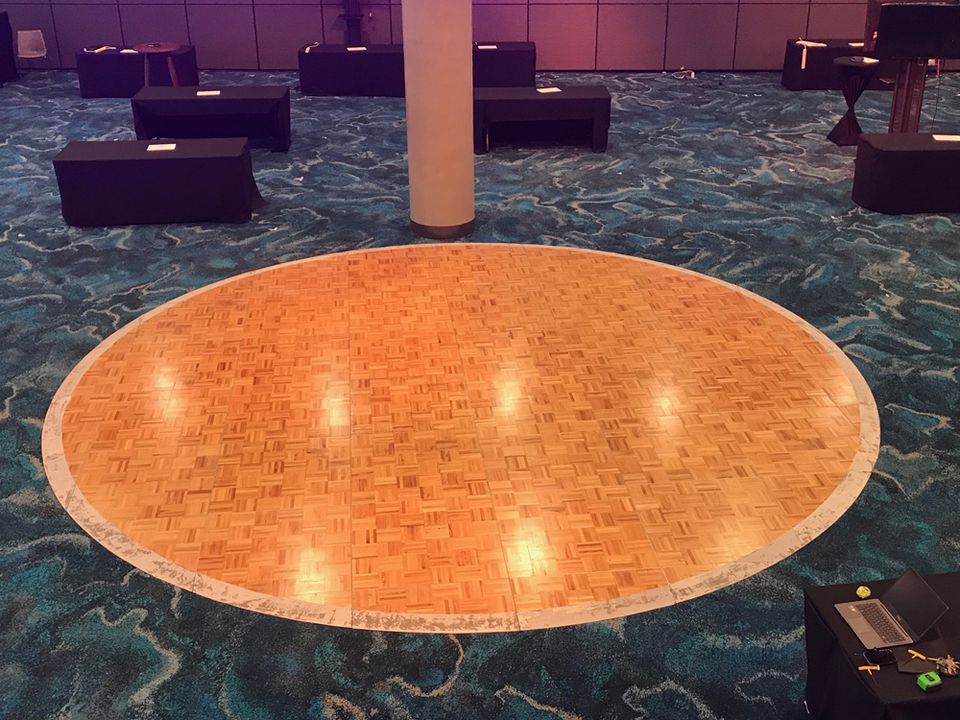 Round timber-look dance floor in a carpeted function room