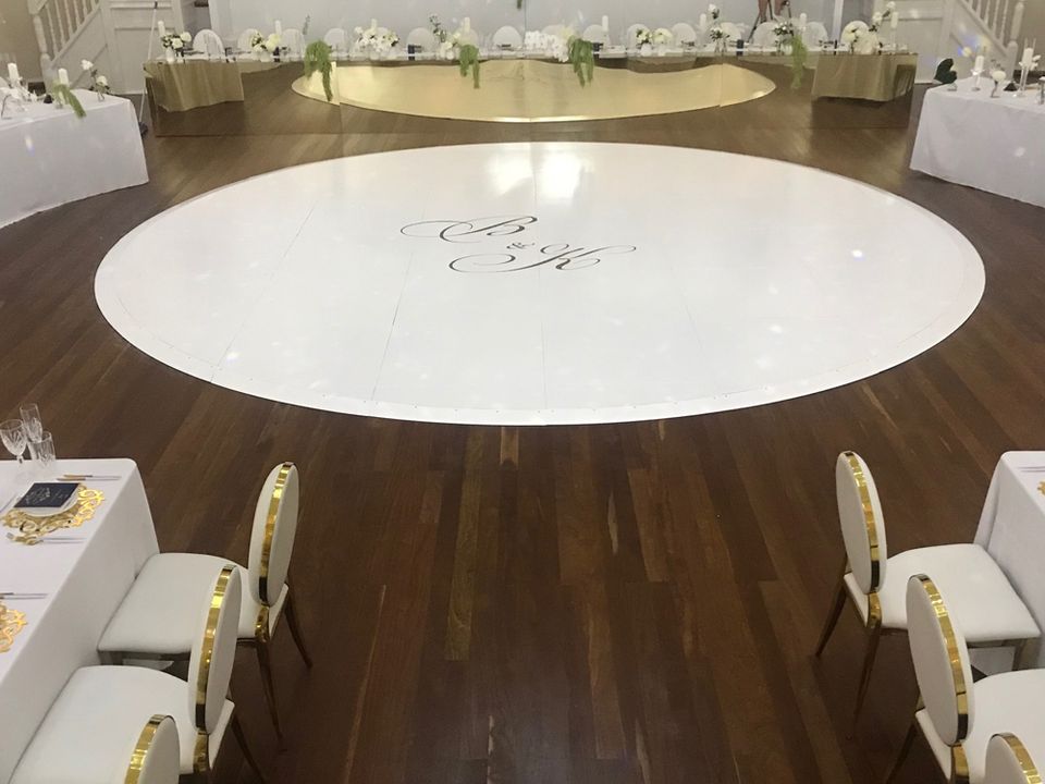 Round white dance floor with a monogram on a timber floor at a wedding reception