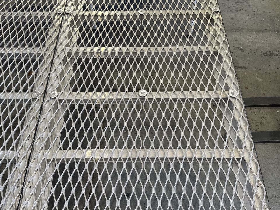 Close view of silver mesh stage deck panels with an angled edge