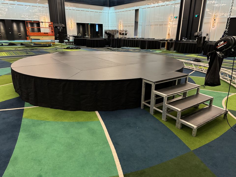 Round black-skirted stage with a step unit in a ballroom