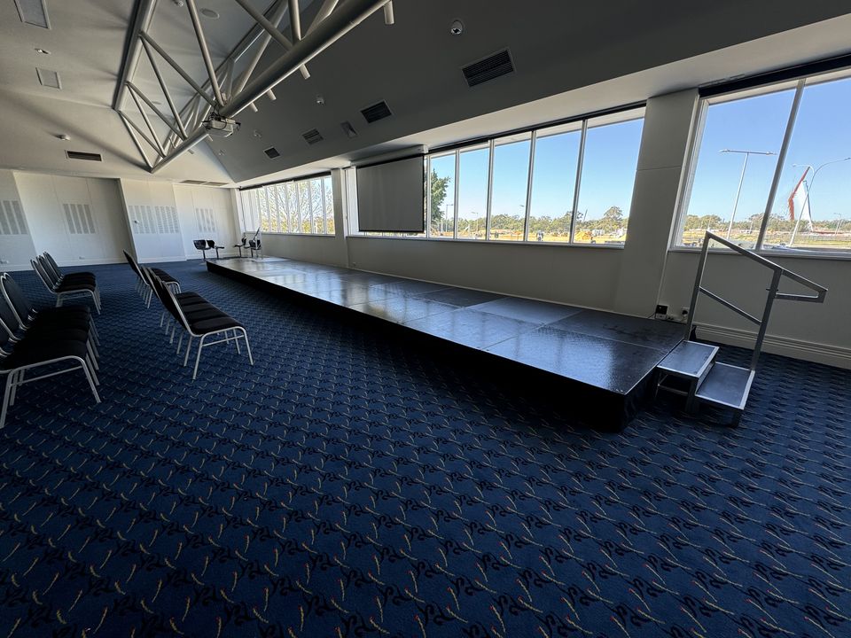Long, low black stage with a step unit along a function room