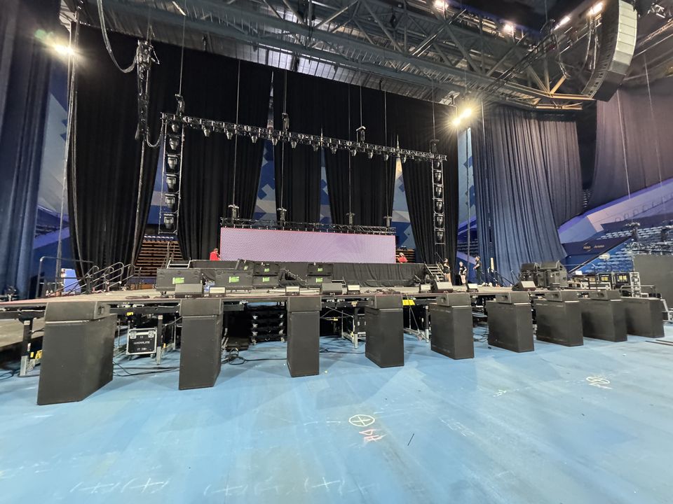 Long black stage deck set up across an arena floor before a show