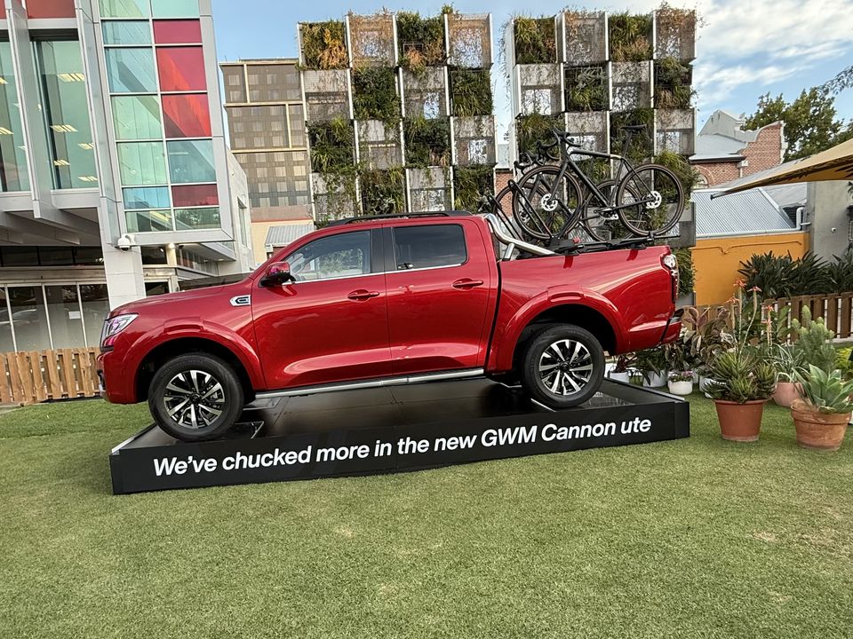 Ute on a black display plinth with a printed fascia on a lawn