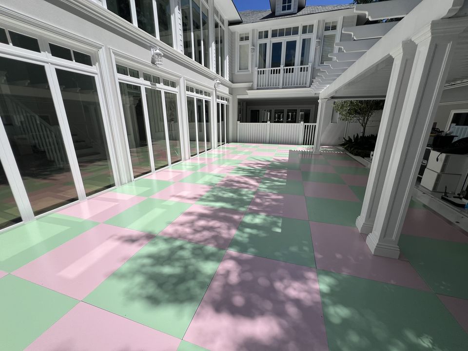 Pink and green checkered floor along a white colonnaded verandah