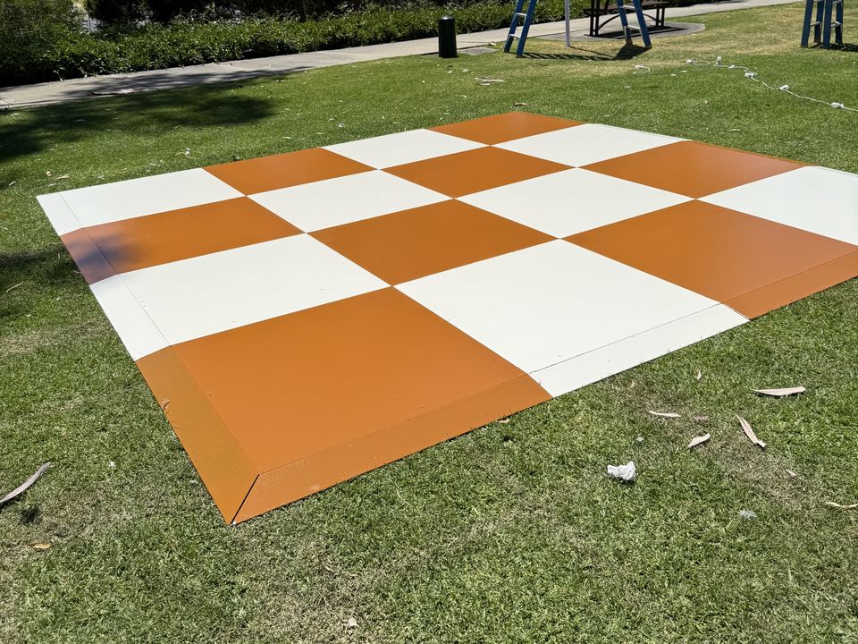 Orange and white checkered dance floor on grass in a park