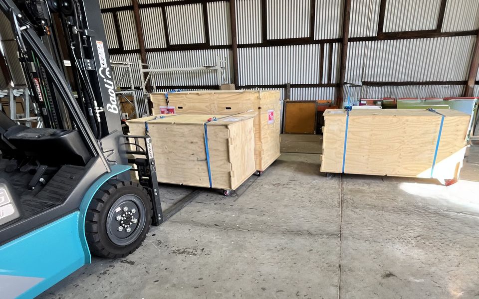 Wooden crates and a forklift inside a storage shed